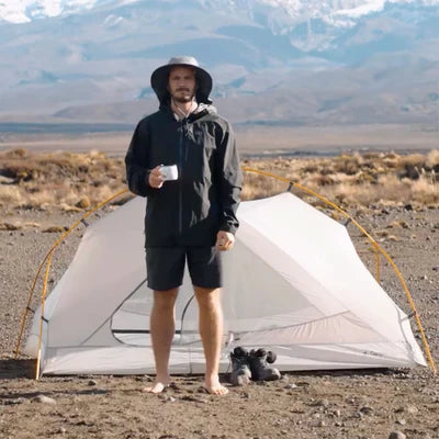 Person standing next to a small tent